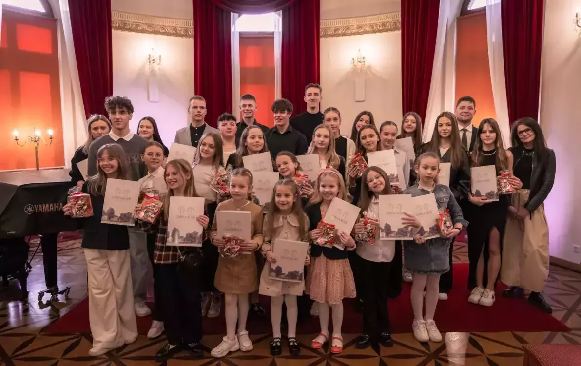 grupa ludzi w szkolnym wieku w sali balowej pozująca do zdjęcia