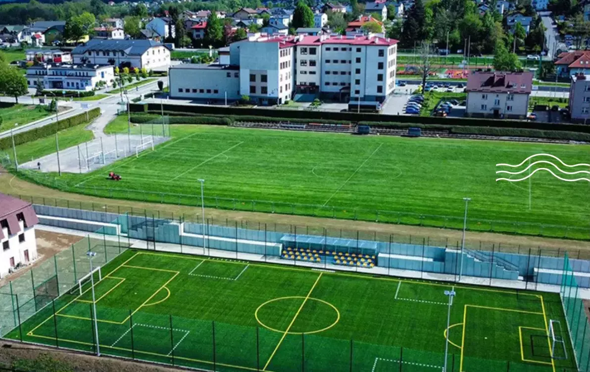 dwa boiska sportowe, z zielona trawą