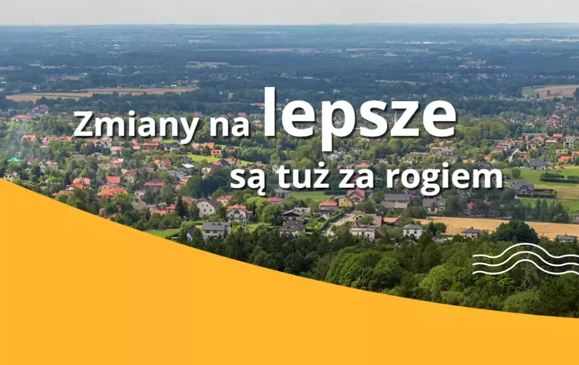 Widok na zieloną okolicę z zabudową jednorodzinną, na tle której biały napis: „Zmiany na lepsze są tuż za rogiem” na żółtym tle w dolnej części grafiki z falistym motywem.