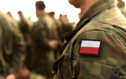ramię żołnieża ubranego w mundur z flaga polski 